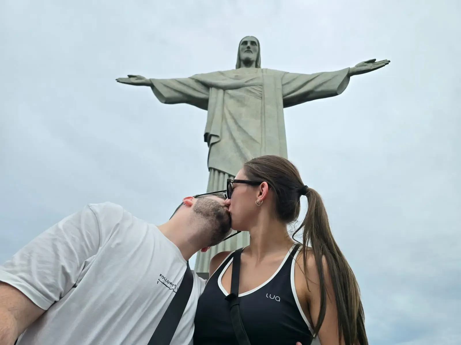 couple kissing at christ the redeemer in rio de janeiro