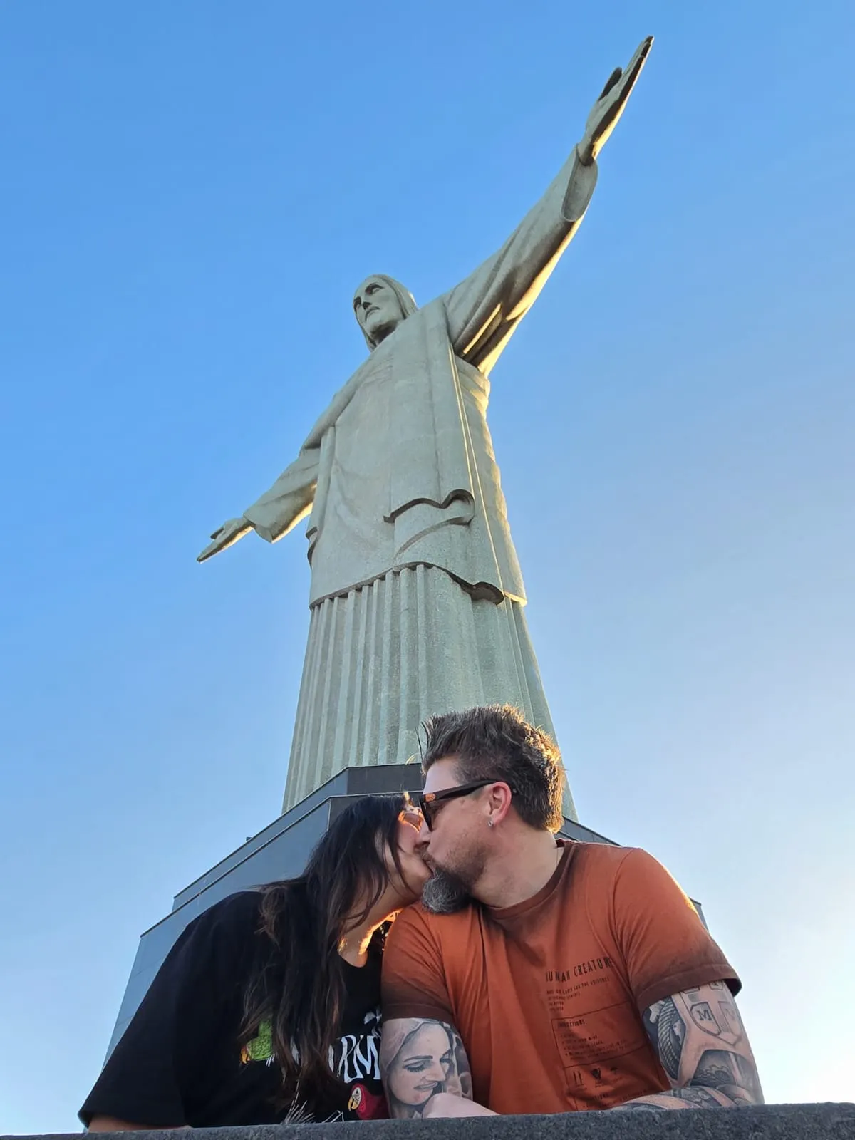 couple kissing in front of the christ the redeemer statue